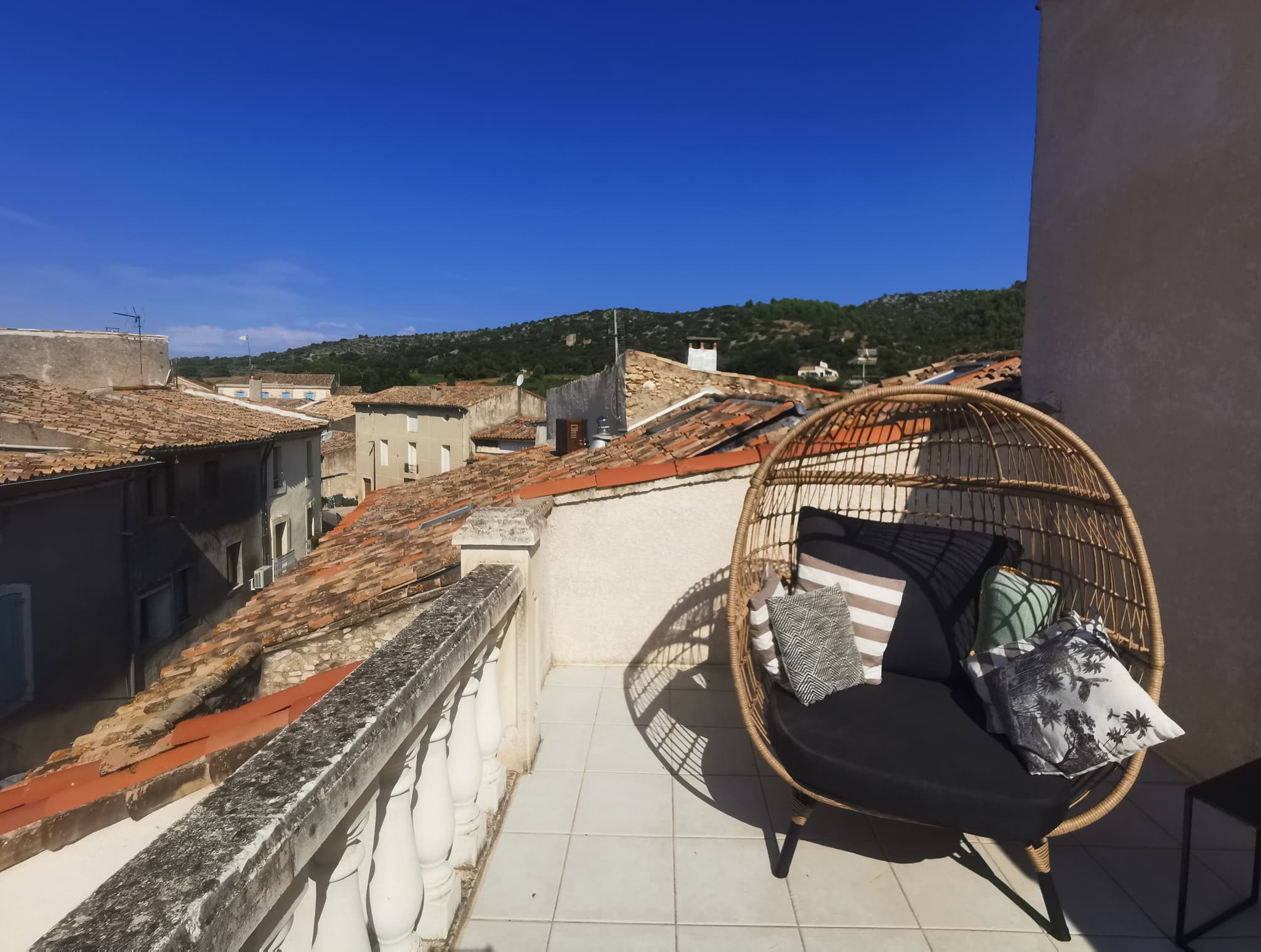 terrasse avec vue sur les toits et collines