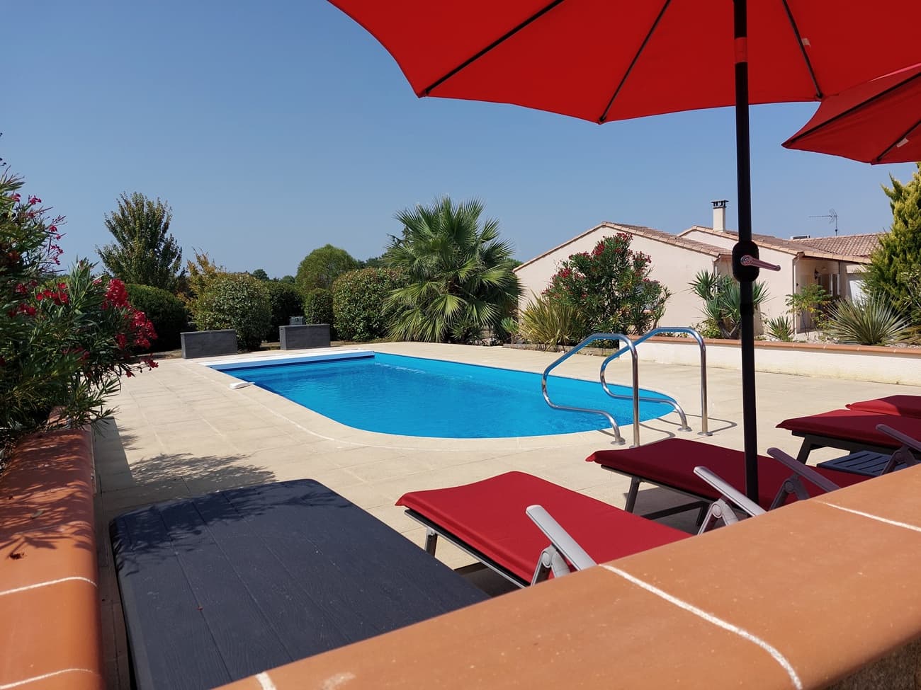 2 parasols zwembad en woning