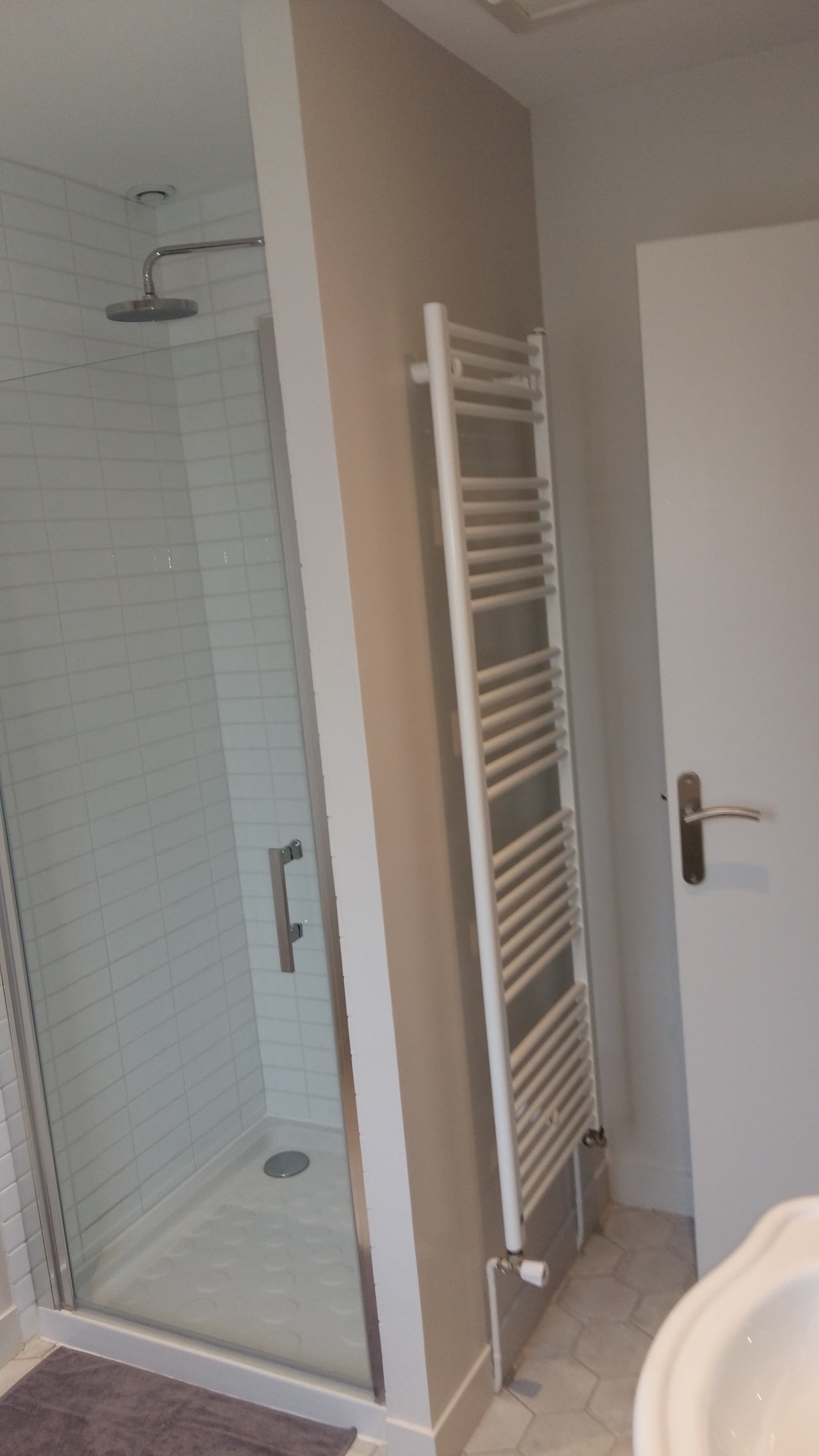 L'entrée de la salle d'eau : douche et sèche serviettes