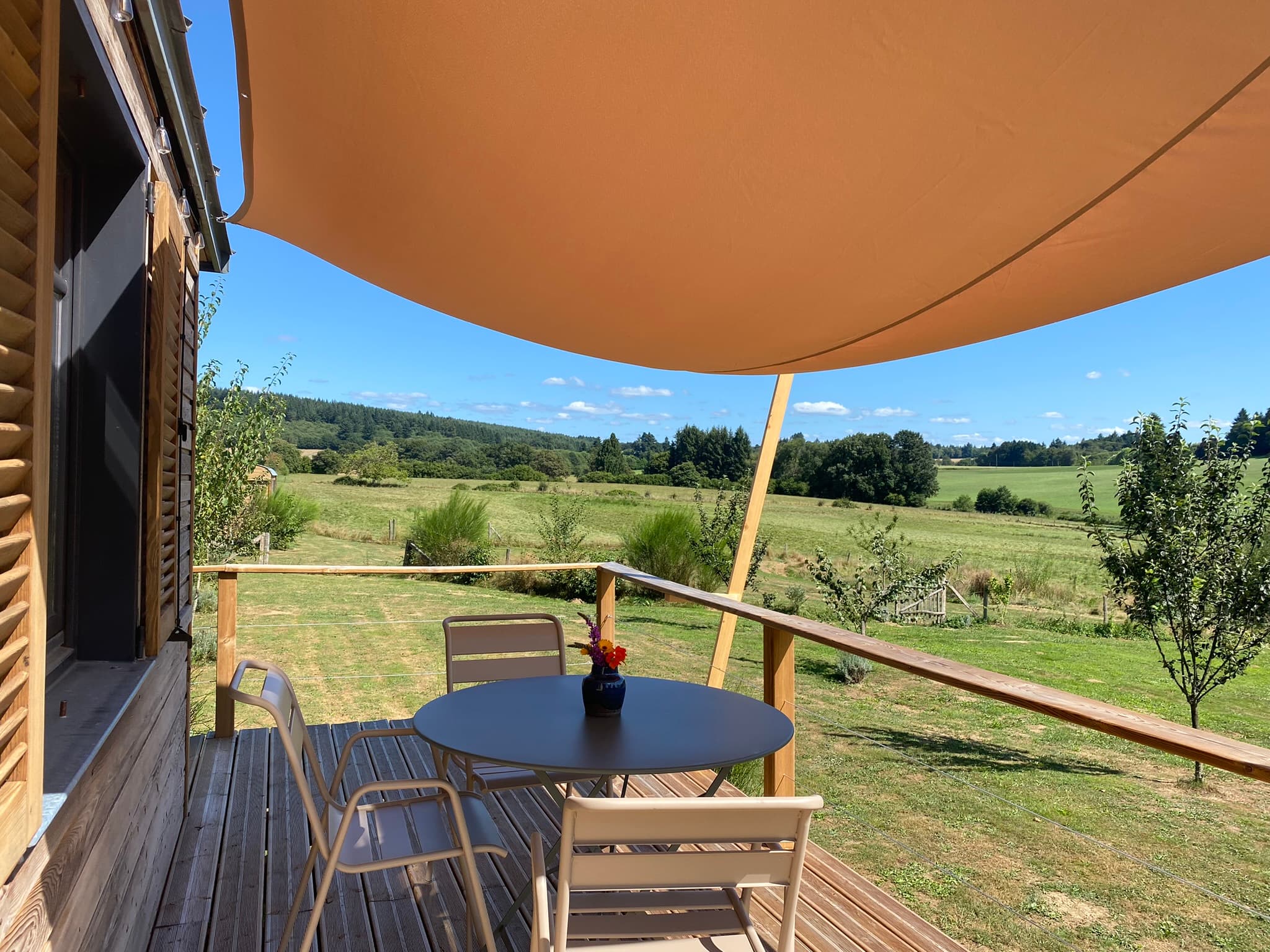 Roulotte du Verger et sa terrasse plein sud donnant sur la nature.
