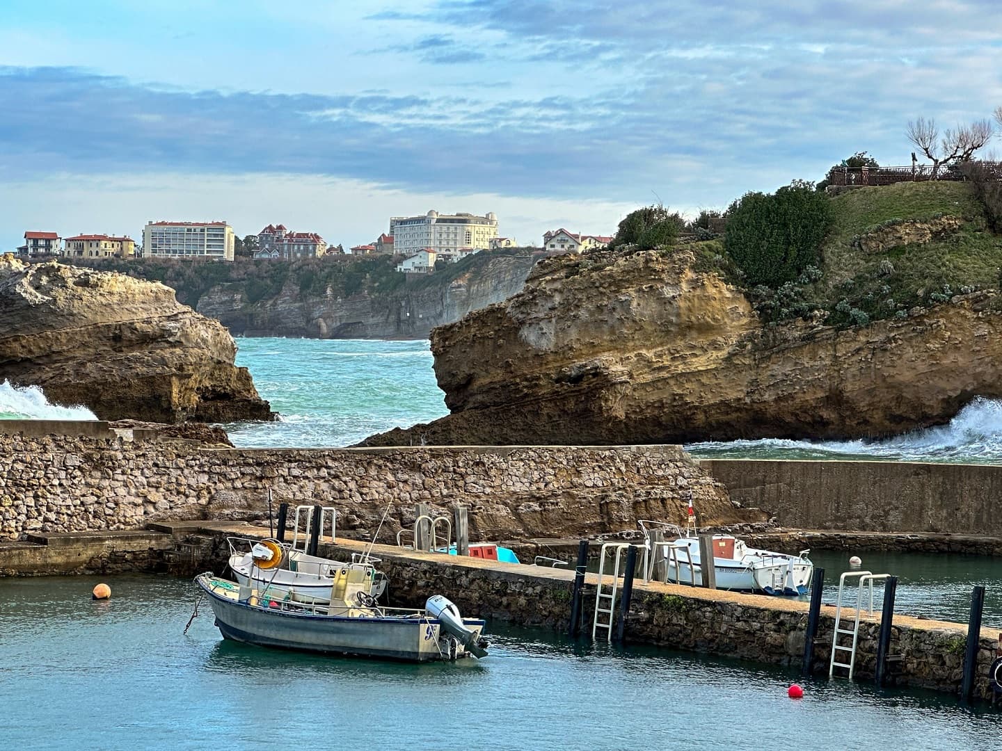 Port des pecheurs avec des bateaux de pêche et l'hôtel Régina au fond