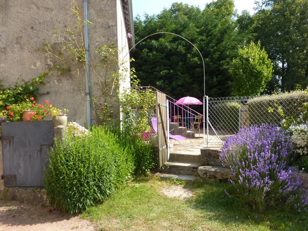 Cour du gîte avec salon de jardin et fauteuils