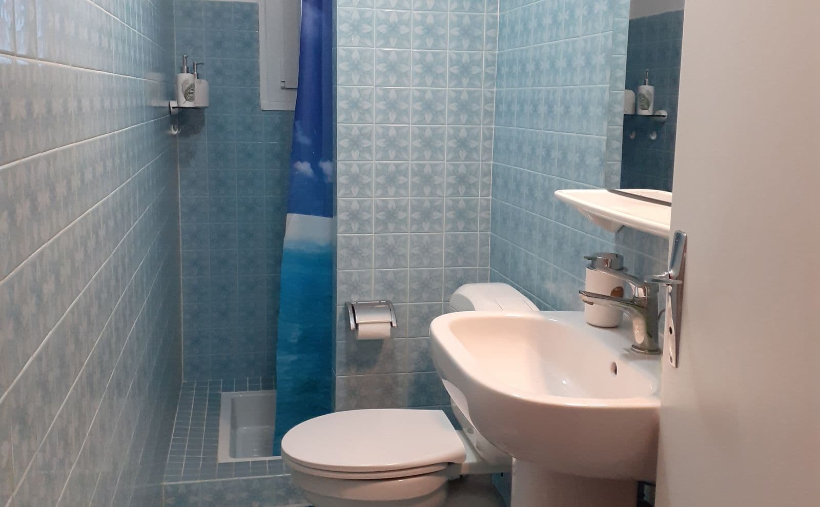 Salle d'eau avec lavabo, douche et wc.