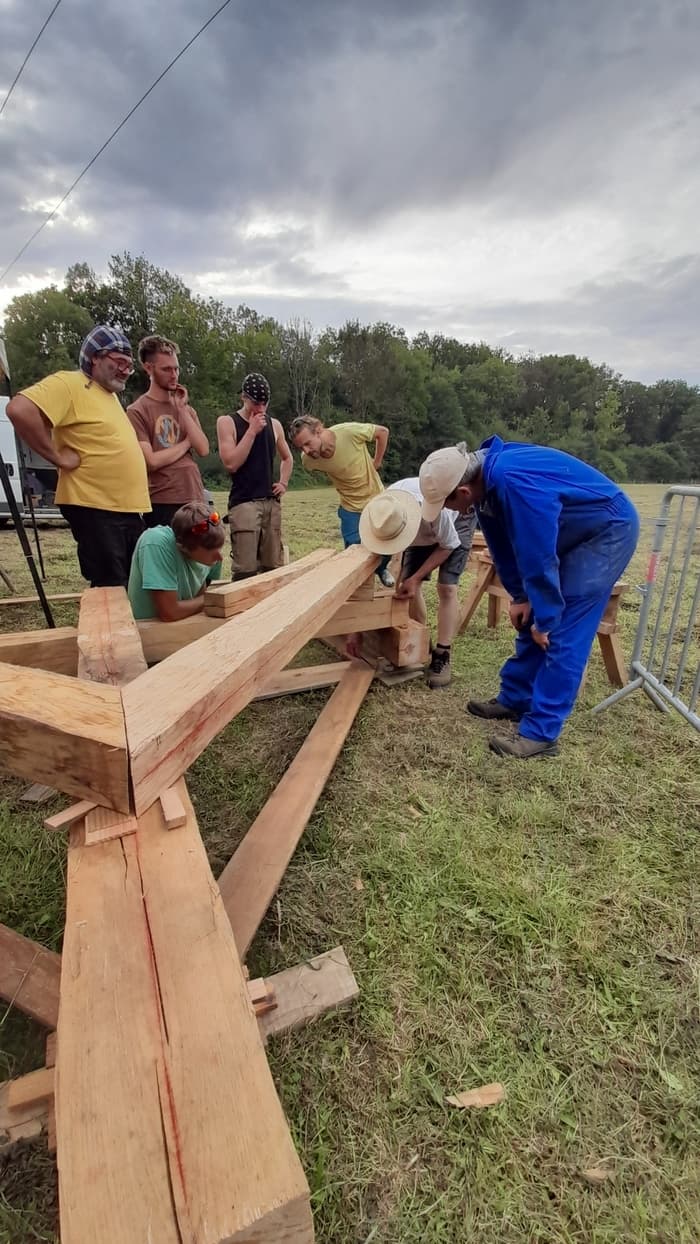 Atelier dessin, taille et assemblage de ferme sur poteaux en troncs de châtaigner équarris à la hache