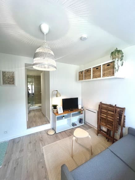 Vue de la pièce principale du studio, avec canapé tv et rangements