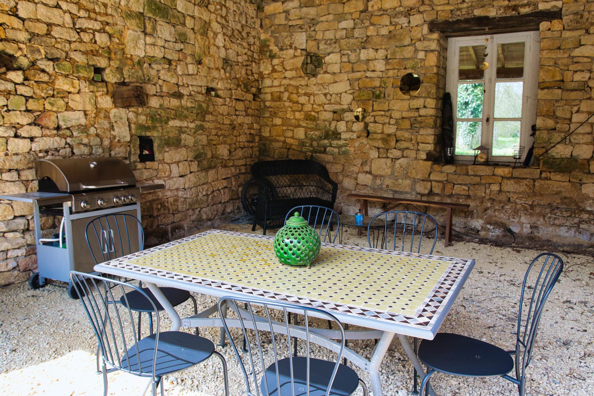 Le préau est aménagé d'un barbecue et de mobilier extérieur.