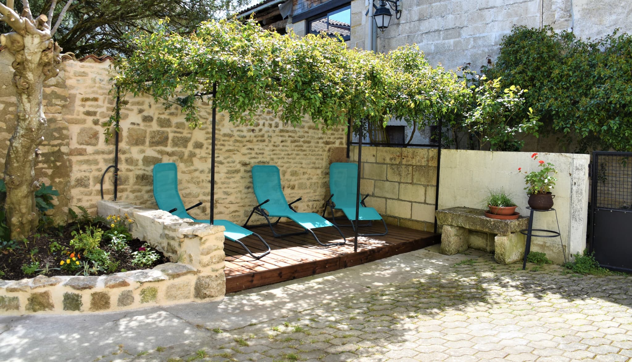 Gîte de la Coulonnerie - Cour avec terrasse fleurie et salon de jardin