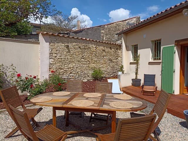La cour avec salon de jardin et transats