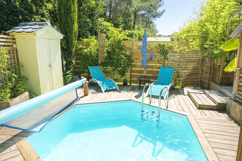Piscine ensoleillée avec fauteuils et terrasse