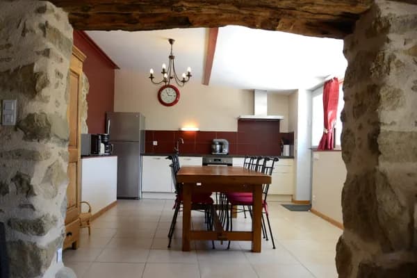 Cuisine vue du salon avec ses pierres apparentes
