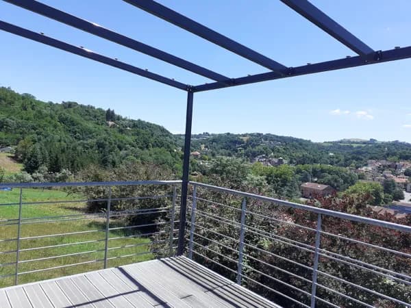 Terrasse avec vue sur Cransac , couverte par un auvent l'été