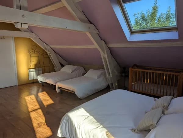 Gîte Panoramique : un hébergement lumineux et chaleureux pensé pour les familles, avec lit double, deux lits simples et un lit bébé. Un espace confortable sous les combles, parfait pour profiter d’un séjour nature en Aveyron.