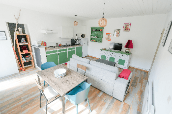 Pièce vie avec cuisine ouverte, coin salle à manger et canapé convertible